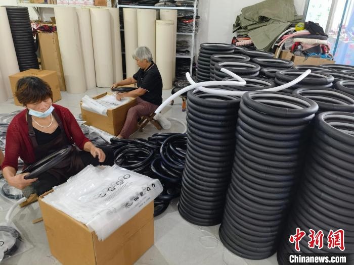 圖為村民在汽車飾品企業(yè)生產(chǎn)車間中工作。　呂子豪 攝