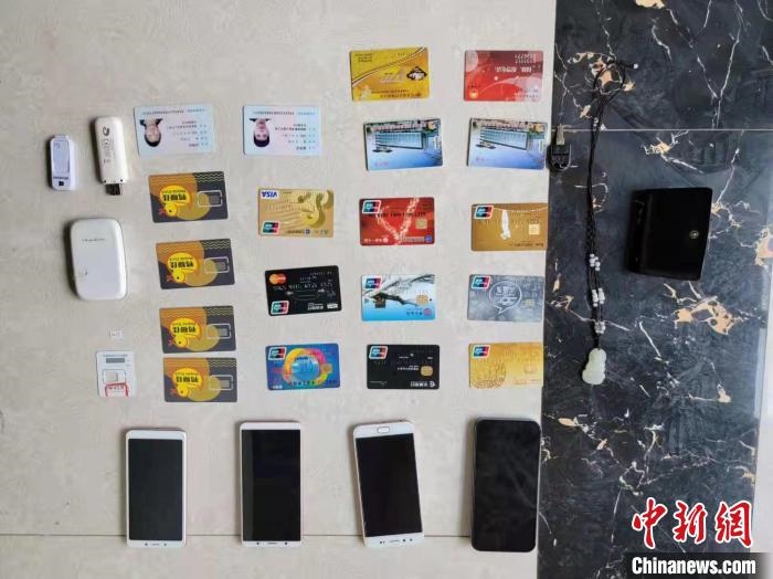 資料圖為果洛藏族自治州公安民警查扣的作案手機(jī)和涉案銀行卡?！‖斍呖h公安局供圖