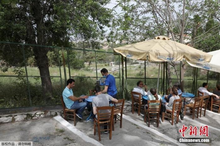 資料圖：希臘雅典，人們在一家露天咖啡享用飲品。