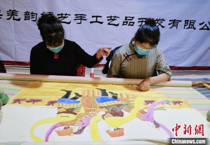圖為皮繡藝人在市集上“秀”指尖技藝?！●R銘言 攝