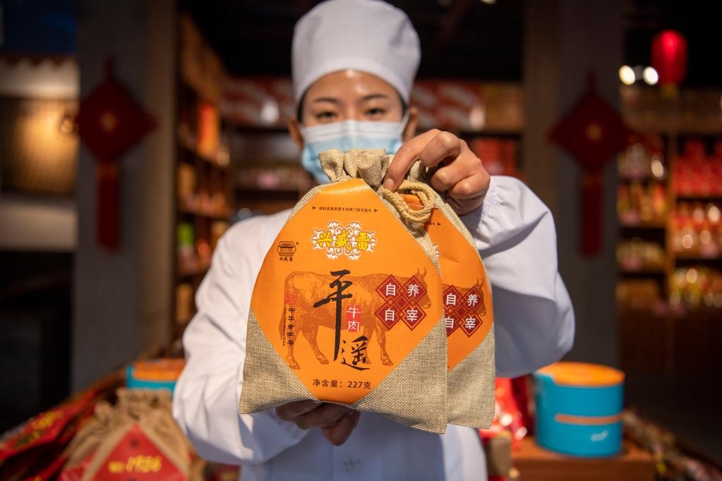 1月27日，在平遙古城南大街的一家平遙牛肉店內(nèi)，工作人員展示一款牛肉產(chǎn)品。新華社記者 楊晨光 攝