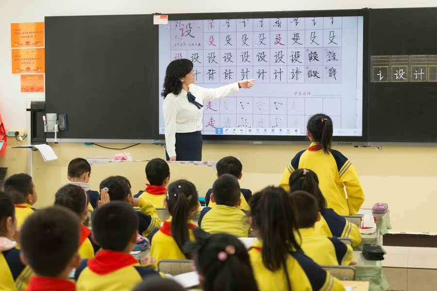 民族路小學(xué)（迎賓校區(qū)），語文老師燕凌云與學(xué)生們共同評(píng)議同學(xué)書寫的漢字.jpg