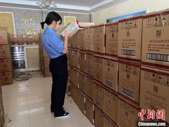 資料圖為檢察人員核對查獲的假冒品牌白酒。青海省人民檢察院供圖