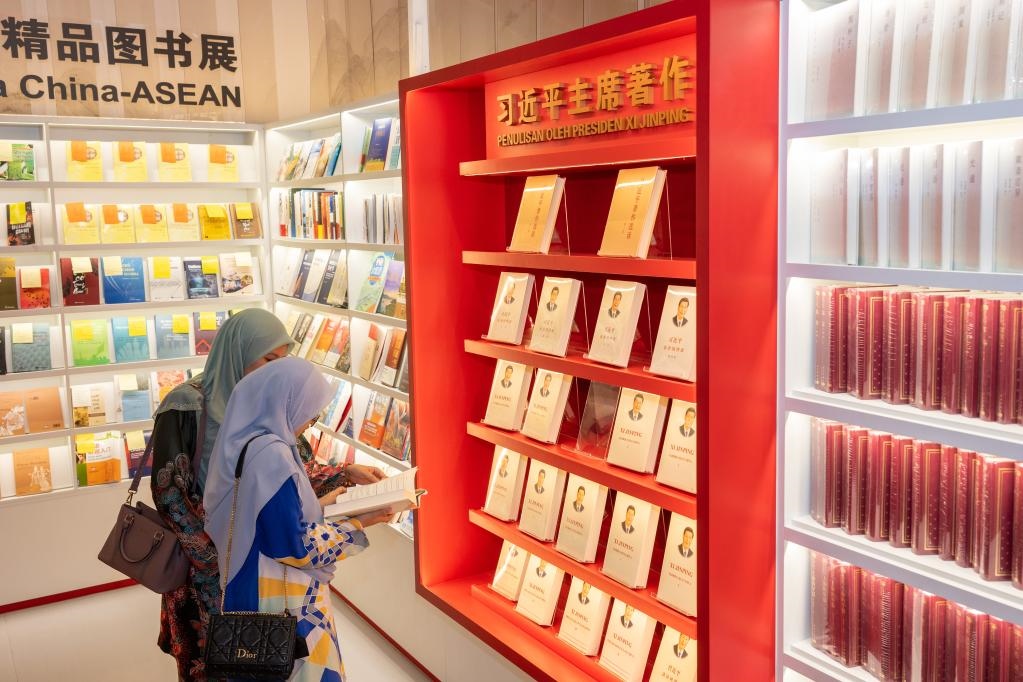 5月30日，兩名讀者在馬來(lái)西亞吉隆坡國(guó)際書(shū)展中國(guó)主賓國(guó)活動(dòng)現(xiàn)場(chǎng)閱讀習(xí)近平主席著作。新華社記者朱煒攝