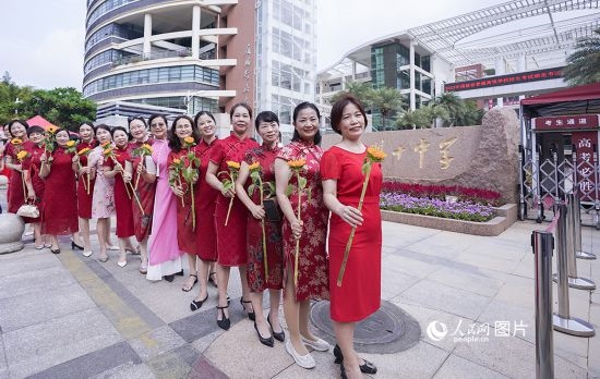 6月7日一早，廈門雙十中學考生家長們身穿旗袍，手拿向日葵在考場外為孩子加油打氣，寓意“旗開得勝，一舉奪魁”。人民網(wǎng)記者 陳博攝