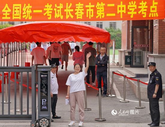 6月7日，在長春市第二中學考點，一名考生信心滿滿進入考場，并與家長揮手致意。人民網(wǎng)記者 李洋攝