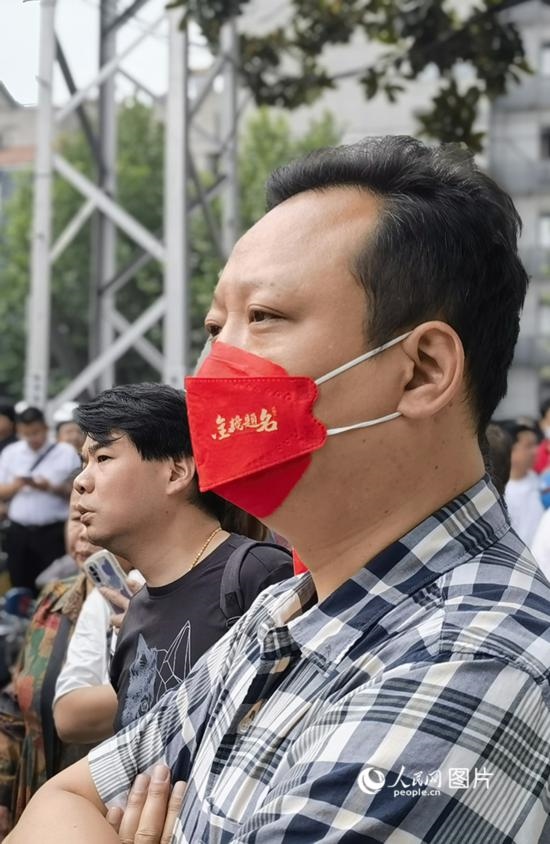 6月7日早，在武漢市第二十六中學考點外，送考家長戴著印有“金榜題名”的口罩。人民網(wǎng) 周雯攝