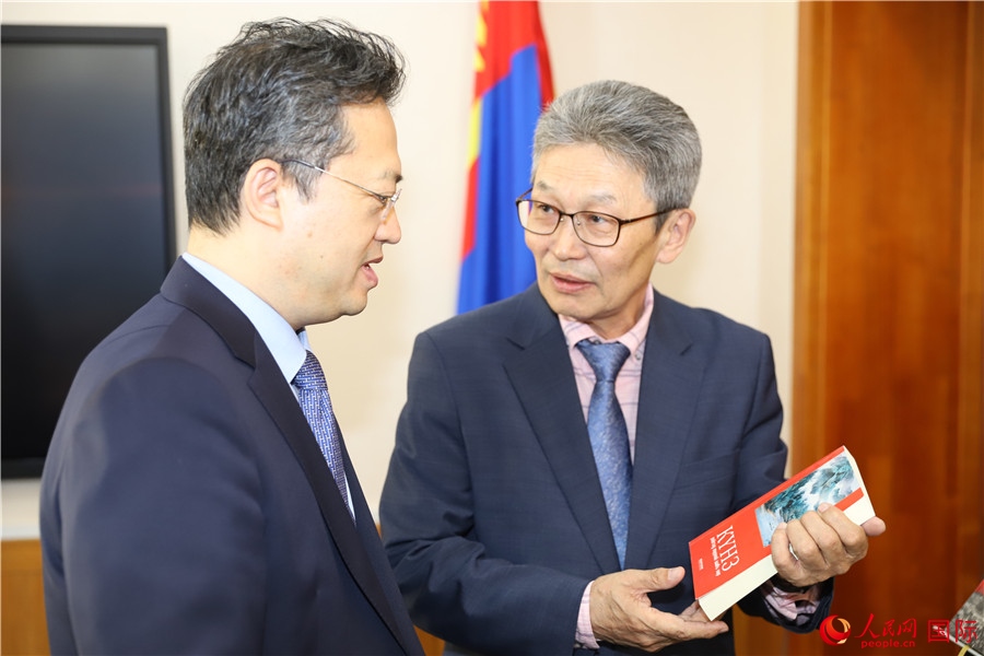 其米德策耶（右一）向李峙介紹翻譯成果。人民網(wǎng)記者 霍文攝
