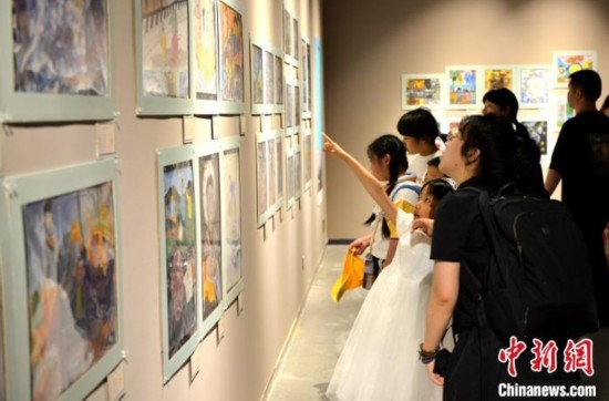 圖為家長帶著孩子參觀展覽。呂明 攝