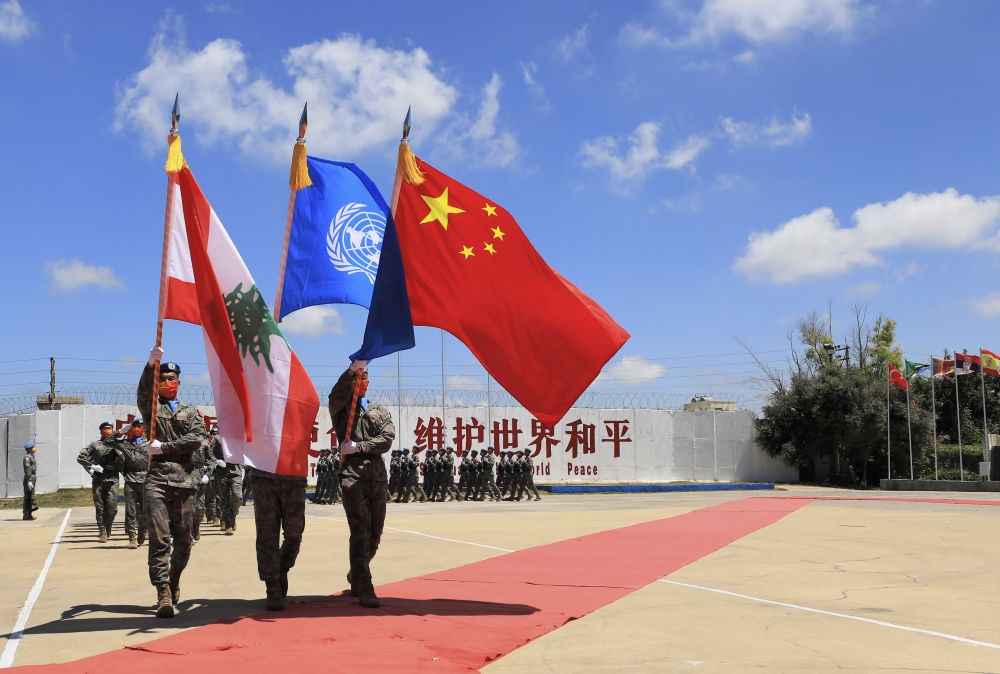 在黎巴嫩南部辛尼亞村的中國維和部隊營區(qū)，中國維和部隊官兵在受勛后通過觀禮臺（2022年7月1日攝）。聯合國駐黎巴嫩臨時部隊（聯黎部隊）當日授予中國第20批赴黎巴嫩維和部隊全體410名官兵聯合國“和平勛章”，以表彰他們?yōu)槔璋湍勰喜康貐^(qū)和平穩(wěn)定作出的突出貢獻。新華社記者 劉宗亞 攝