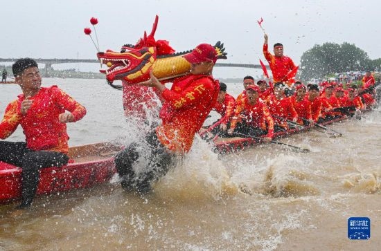 6月22日，在湖南省岳陽市湘陰縣湘江臨資口水域，參加龍舟賽的隊員接“龍頭”下水。
