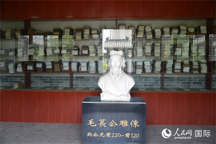 河間詩(shī)經(jīng)齋毛萇雕像。雕像后書(shū)櫥中陳列的是歷代各版本《詩(shī)經(jīng)》及譯本。 人民網(wǎng) 趙昭攝