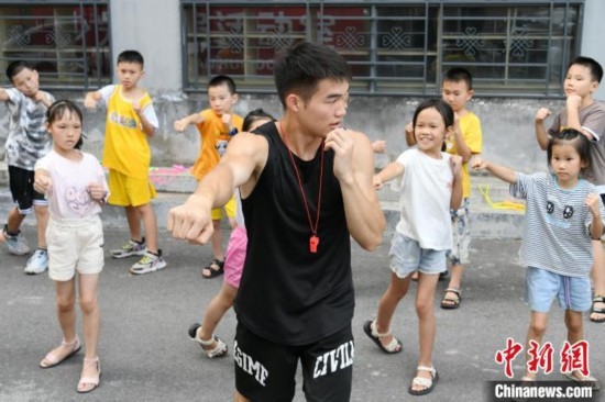 圖為大學(xué)生志愿者在組織孩子們參加體育健身活動(dòng)。廖光福 攝