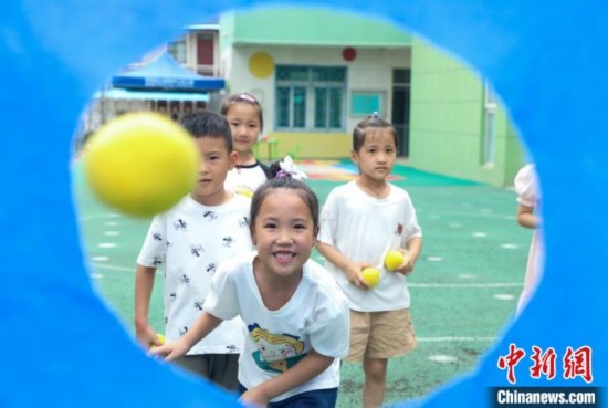 在肥西縣山南鎮(zhèn)中心幼兒園，孩子們在玩布洞投球游戲。陳家樂 攝