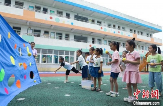 在肥西縣山南鎮(zhèn)中心幼兒園，孩子們在玩布洞投球游戲。陳家樂 攝