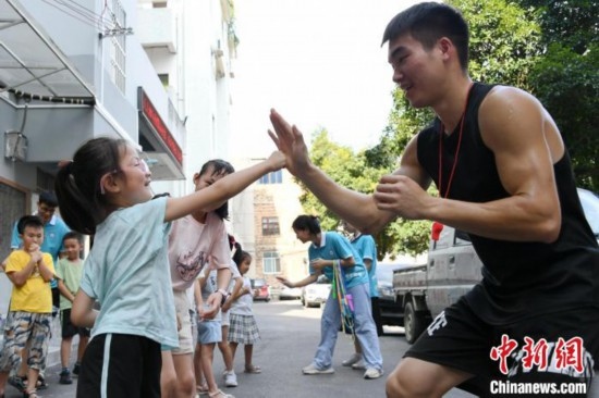 圖為大學(xué)生志愿者在組織孩子們參加體育健身活動(dòng)。廖光福 攝