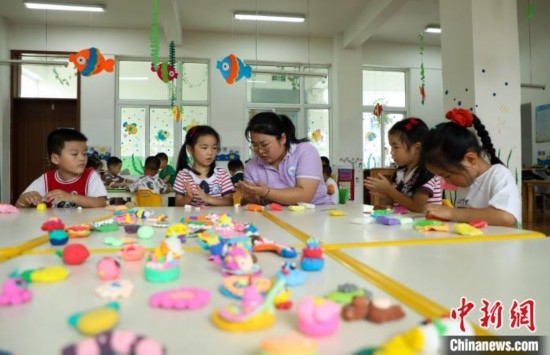 在肥西縣山南鎮(zhèn)中心幼兒園，孩子們在老師的指導(dǎo)下做彩色泥塑。陳家樂 攝