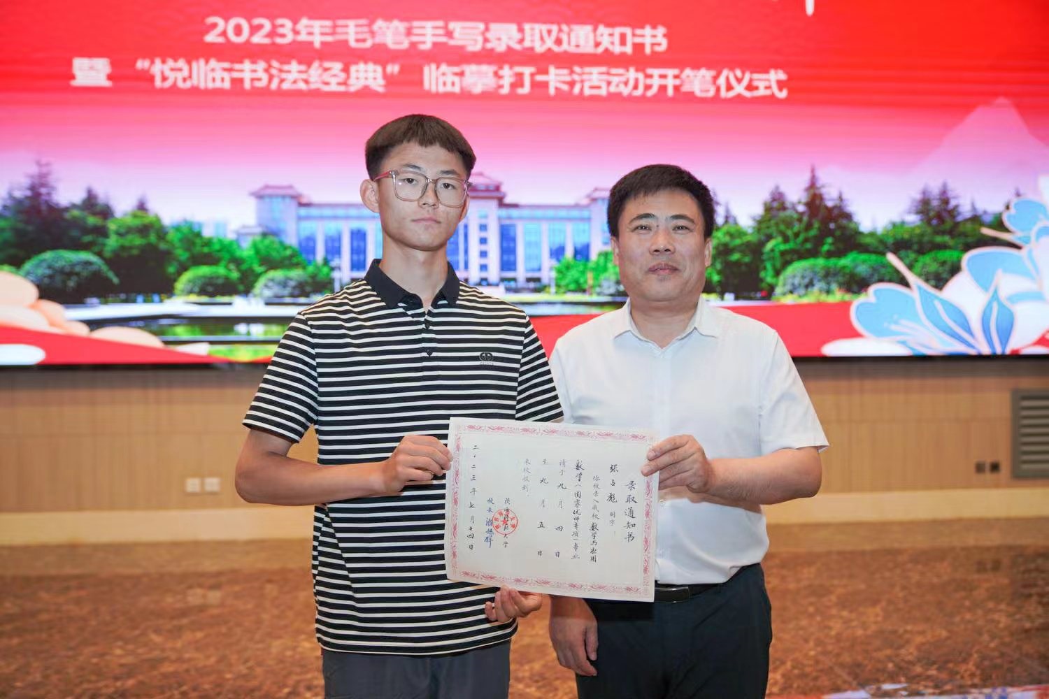 陜西師范大學(xué)黨委書記李忠軍為2023級新生代表張占彪同學(xué)發(fā)放錄取通知書。校方供圖