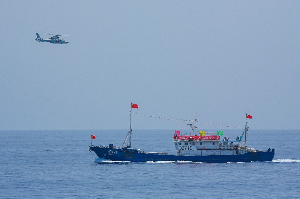 ↑中國海軍第40批護(hù)航編隊(duì)中的艦載直升機(jī)在被護(hù)船只周邊海域巡邏警戒（2022年6月4日攝）。新華社發(fā)（唐文 攝）