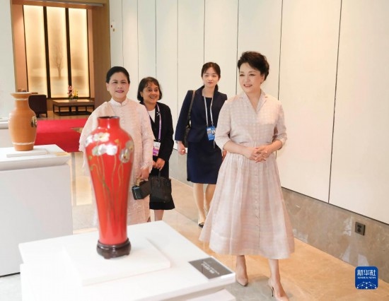 7月27日下午，國家主席習近平夫人彭麗媛在四川成都會見陪同印度尼西亞總統(tǒng)佐科來華出席第31屆世界大學(xué)生夏季運動會開幕式并訪華的總統(tǒng)夫人伊莉亞娜。這是彭麗媛和伊莉亞娜欣賞成都特色非遺工藝品。新華社記者 丁林 攝