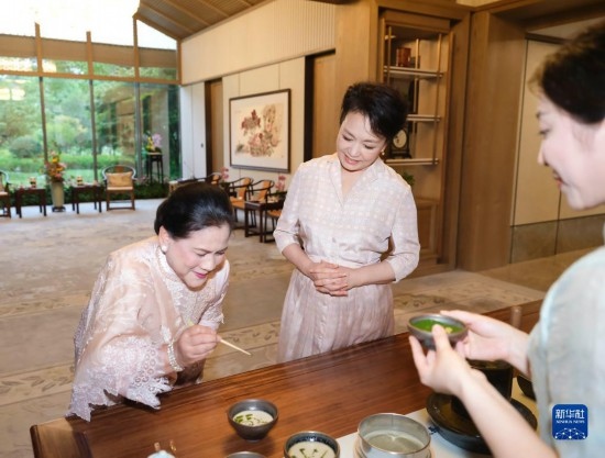 7月27日下午，國家主席習近平夫人彭麗媛在四川成都會見陪同印度尼西亞總統(tǒng)佐科來華出席第31屆世界大學(xué)生夏季運動會開幕式并訪華的總統(tǒng)夫人伊莉亞娜。這是彭麗媛邀請伊莉亞娜觀看茶藝表演，并同伊莉亞娜親切茶敘。新華社記者 丁林 攝