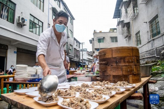 7月29日，在重慶市綦江區(qū)安穩(wěn)鎮(zhèn)，當地居民在“苗家伏羊節(jié)”上準備羊肉長桌宴。新華社記者 唐奕 攝
