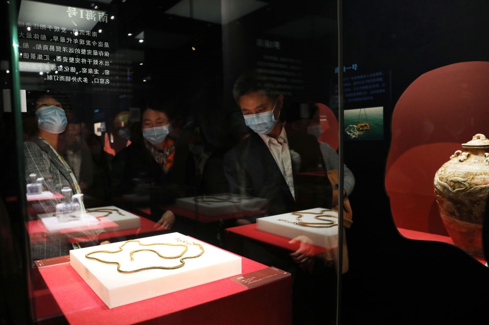 參觀者在上海臨港新城的中國航海博物館航海文物展上的“南海一號”出水的宋代金項飾展柜前駐足觀看（2020年12月28日攝）。新華社記者 方喆 攝