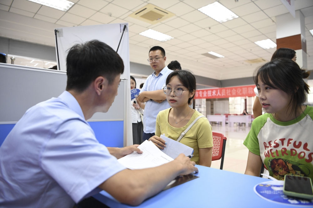 2023年7月29日，“揚(yáng)就業(yè)之帆，啟夢(mèng)想之旅”2023年寧夏（銀川）離校未就業(yè)高校畢業(yè)生招聘會(huì)在寧夏（銀川）人力資源服務(wù)產(chǎn)業(yè)園舉行。求職者（右）在招聘會(huì)現(xiàn)場(chǎng)與用人單位交流。新華社記者 馮開(kāi)華 攝
