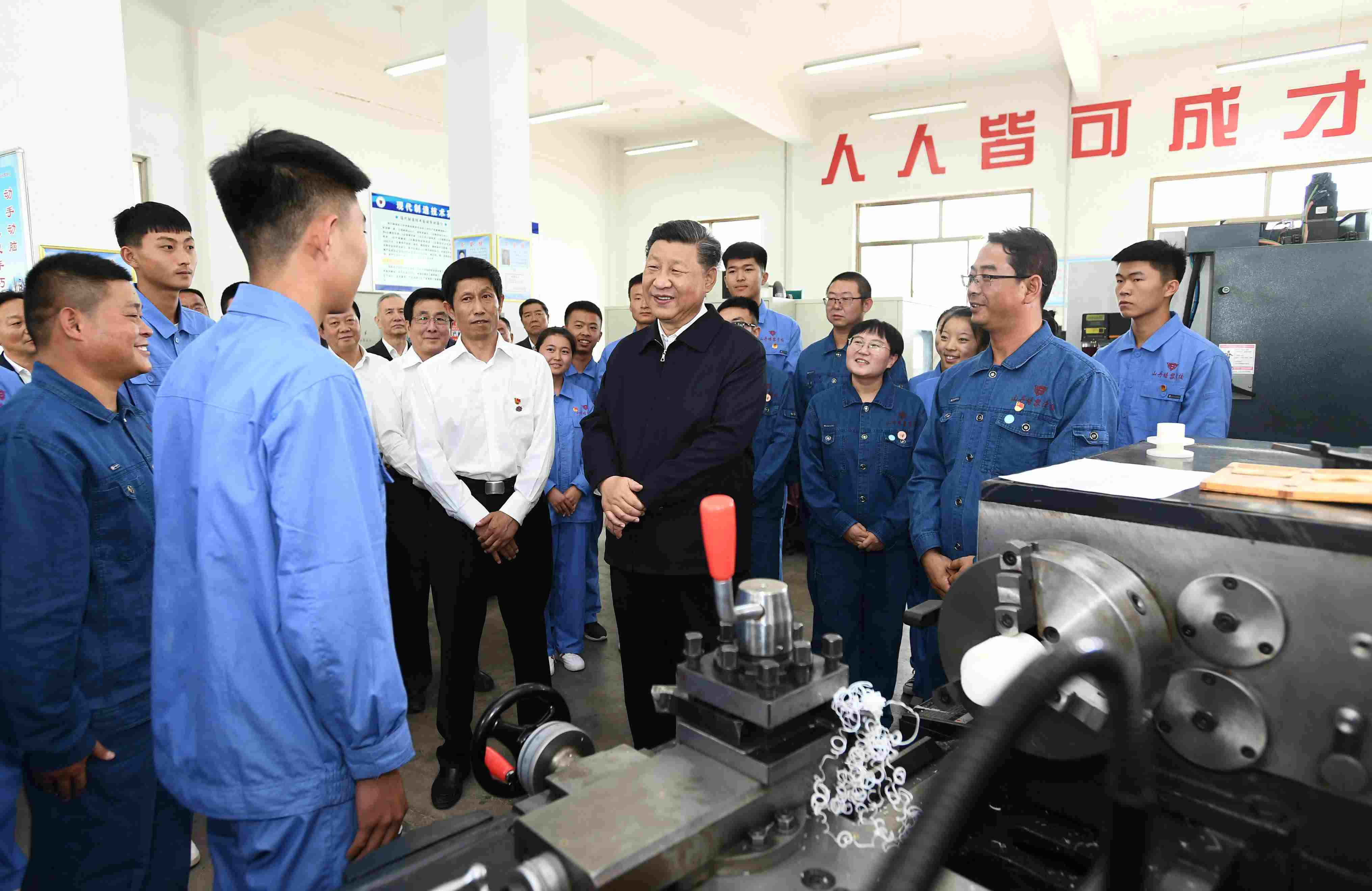 2019年8月20日，習(xí)近平在甘肅省張掖市山丹培黎學(xué)?，F(xiàn)代制造技術(shù)實(shí)訓(xùn)室，觀看職業(yè)技能實(shí)訓(xùn)，同師生親切交流。