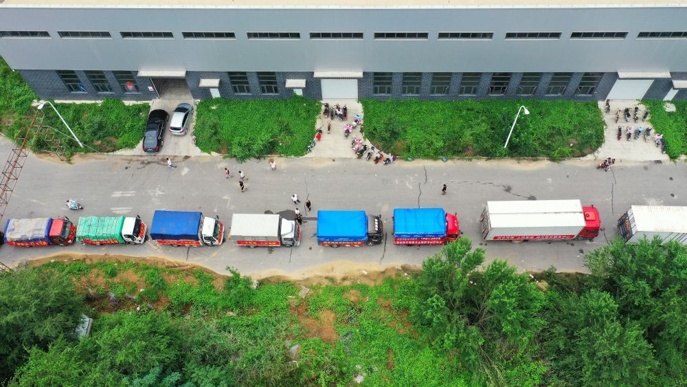 在河北省涿州市鋼研物資儲備點(diǎn)外，運(yùn)送物資的車輛排起長隊(duì)（8月5日攝，無人機(jī)照片）。新華社記者 牟宇 攝
