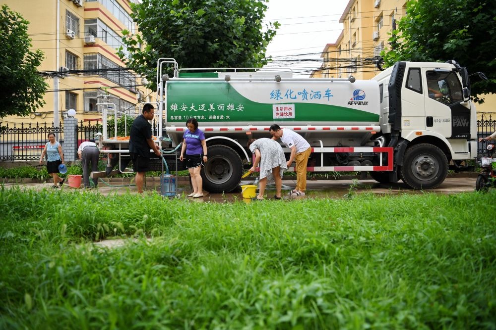河北省涿州市新星小區(qū)居民從供水車?yán)锝铀?月4日攝）。新華社記者 牟宇 攝