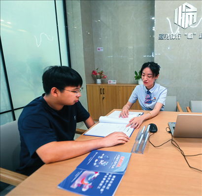在杭州市臨安區(qū)政務服務中心的“為企服務中心”，黨員志愿者（右）解答企業(yè)主的疑問（2023年7月7日攝）。徐昱攝/本刊