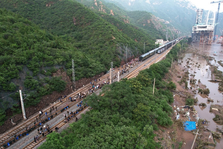 8月2日，受困列車旅客在救援人員幫助下徒步趕往轉(zhuǎn)運客車（無人機照片）。新華社記者 張晨霖 攝
