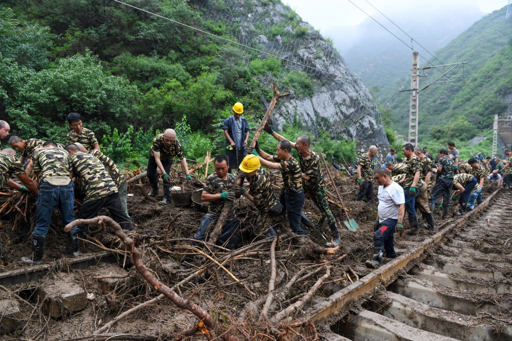 8月1日，在北京市門頭溝區(qū)水峪嘴村附近一段被阻斷的鐵路線上，中鐵六局工作人員在清理軌道上的雜物，全力恢復交通。新華社記者 鞠煥宗 攝