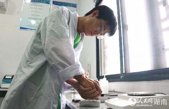 吳健筆在獼猴桃科技小院實驗室測量水果糖分。 人民網(wǎng)記者 劉賓攝