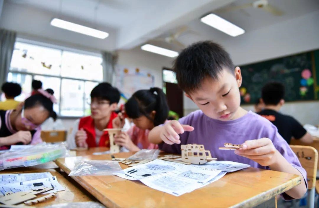 △今年7月，在浙江余姚市舜北小學(xué)暑托班內(nèi)，孩子們制作太陽能科學(xué)實驗裝置。