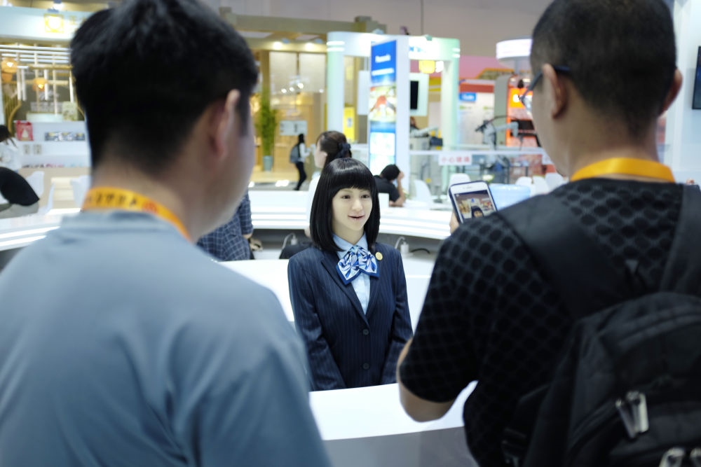 9月1日，媒體記者在國家會議中心與服務(wù)機(jī)器人互動。新華社記者 劉夢琪 攝