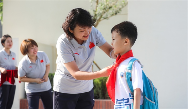 8月30日，雄安史家胡同小學(xué)學(xué)生體驗(yàn)學(xué)校生活。老師為學(xué)生佩戴校徽。