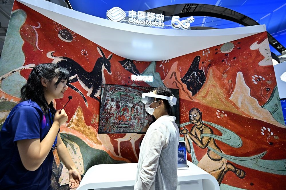 9月3日，一名參觀者在首鋼園中國移動展臺體驗基于AR/VR特效的敦煌導(dǎo)覽，沉浸式感受敦煌壁畫的魅力。新華社記者 李鑫 攝
