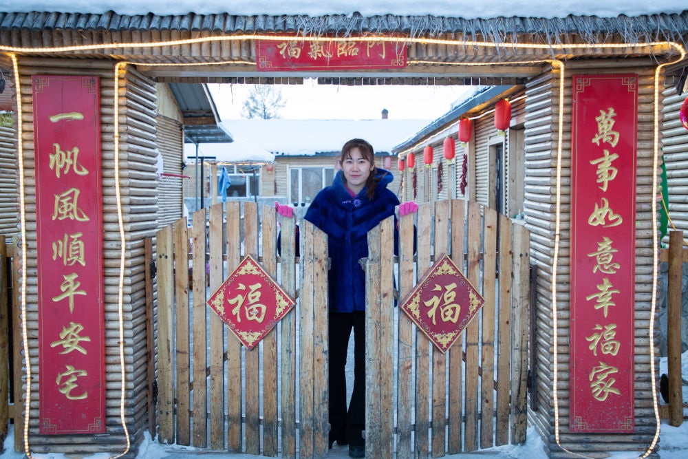 北極村民宿經(jīng)營者史瑞娟在門前迎候入住的游客（2023年1月7日攝）。