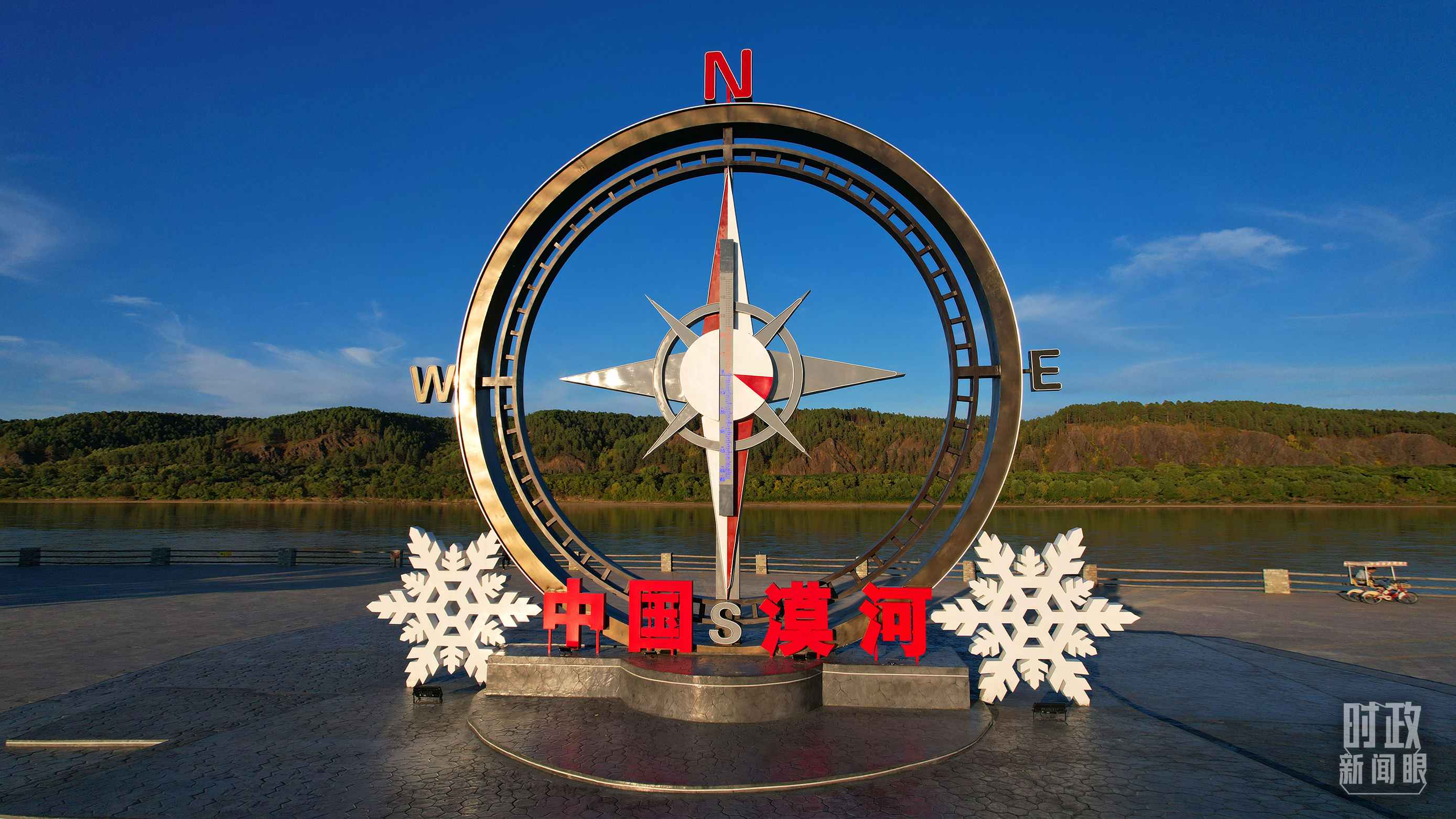 △指北針雕塑是北極村標志性建筑之一，其紅色指針指向正北方。上面的大型溫度計高12.22米，象征北極村位于東經(jīng)122°20′。（總臺央視記者范凱拍攝）