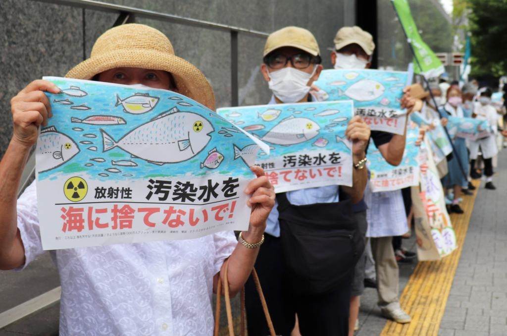 8月24日，日本民眾手持“不要將污染水扔進(jìn)大?！钡葮?biāo)語在東京電力公司總部前集會，抗議日本政府和東電公司無視民意啟動核污染水排海。新華社記者楊光攝