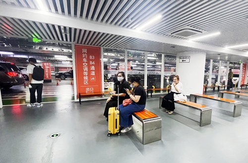 旅客在網(wǎng)約車空調等候區(qū)等候網(wǎng)約車。人民網(wǎng)記者 喬雪峰攝