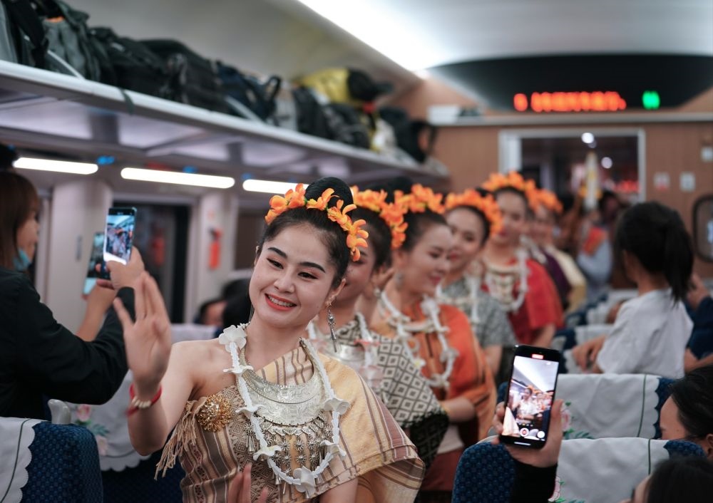 2023年4月13日，老撾工作人員在中老鐵路上開行的D887次國際旅客列車上表演。新華社記者 邢廣利 攝