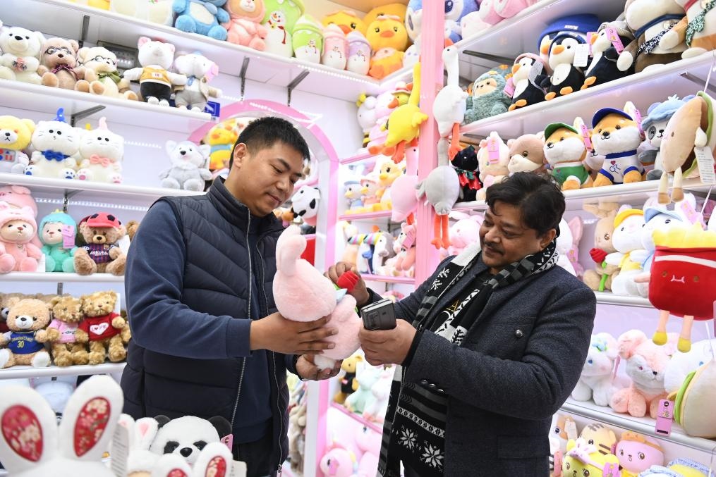 2023年2月2日，來自印度的客商（右）在義烏國際商貿(mào)城的一家玩具店鋪內(nèi)選購商品。新華社記者 黃宗治 攝