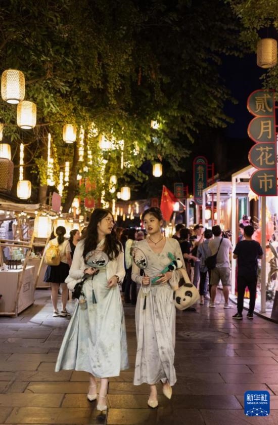 在成都寬窄巷子，兩位來(lái)自安徽的游客在新“十二月市”街區(qū)游覽（9月29日攝）。