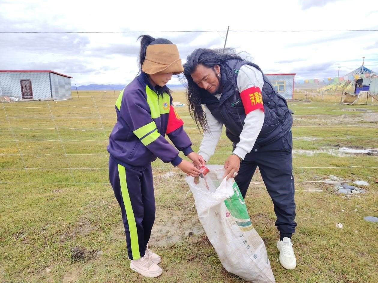 玉樹(shù)州稱多縣珍秦鎮(zhèn)河湖志愿者才培和他女兒更求拉毛在清掃垃圾。受訪者供圖