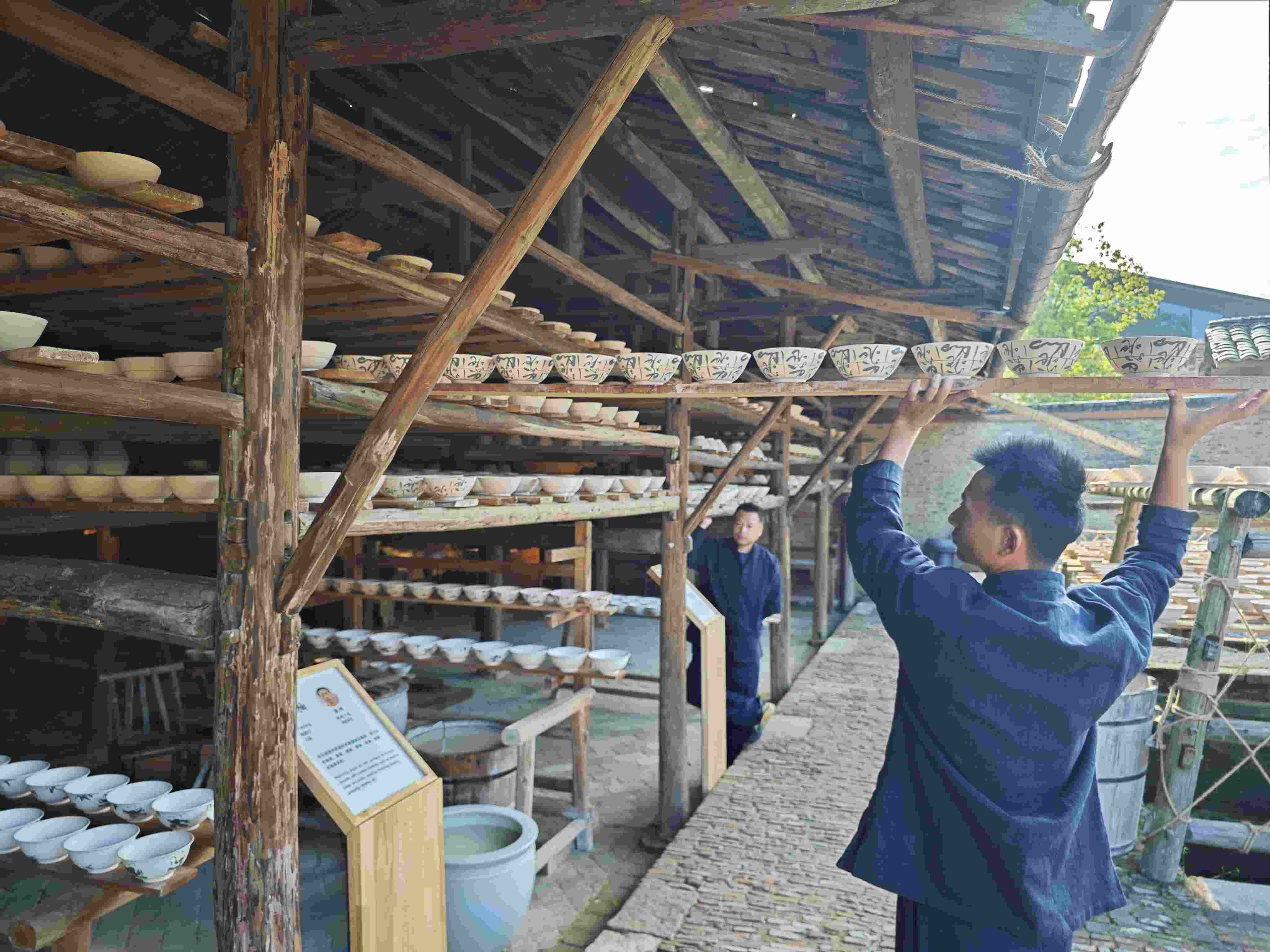△陶陽(yáng)里歷史文化街區(qū)里，工匠將陶瓷工藝品放到架上晾干。（總臺(tái)央視記者彭漢明拍攝）
