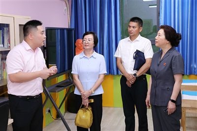 圖③：“小公民法律課堂”開(kāi)講前，全國(guó)人大代表殷其龍（右二）、重慶市人大代表李自玲（左二）聽(tīng)取楊家坪中學(xué)負(fù)責(zé)人關(guān)于未成年人思想教育工作情況的介紹。