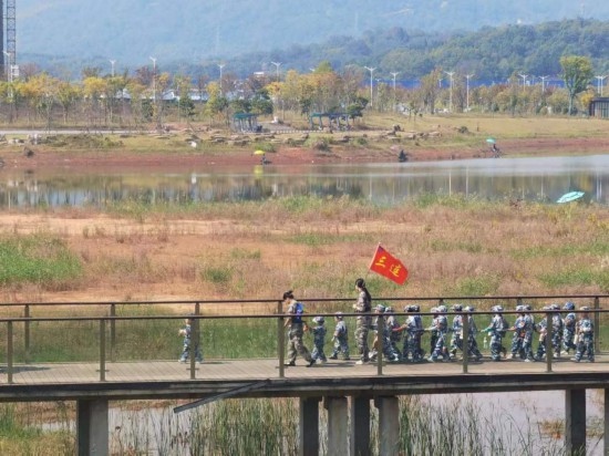 10月24日，秋游的幼兒園小朋友在老師帶領(lǐng)下走在清水塘公園里的木橋上。本報記者 常雯宜攝
